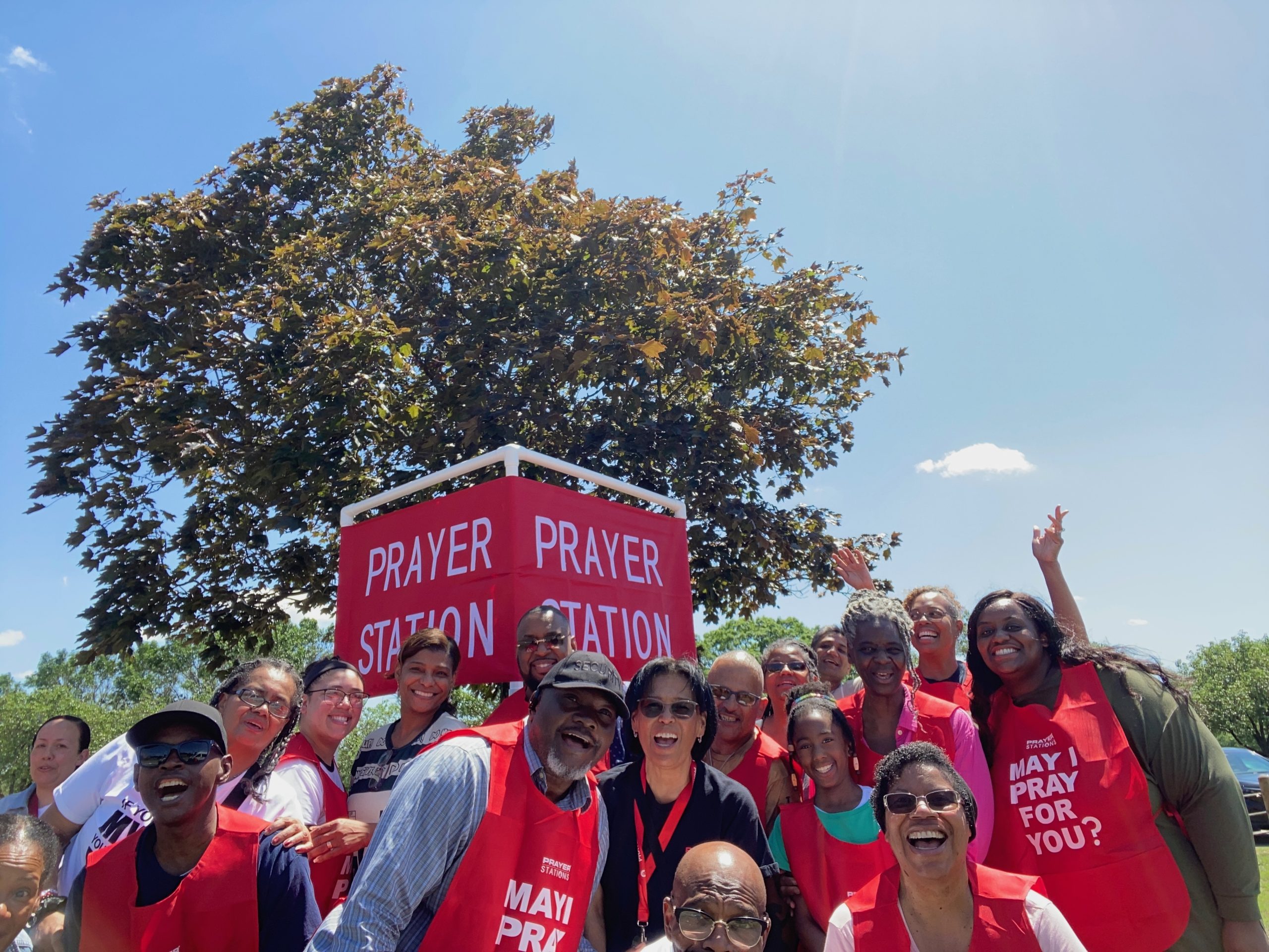 Prayer Station outreach team gathered beside their red prayer station sign